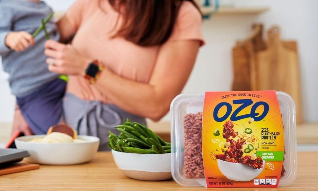 a close up on vegetarian planterra mince with a mother and her child in the background