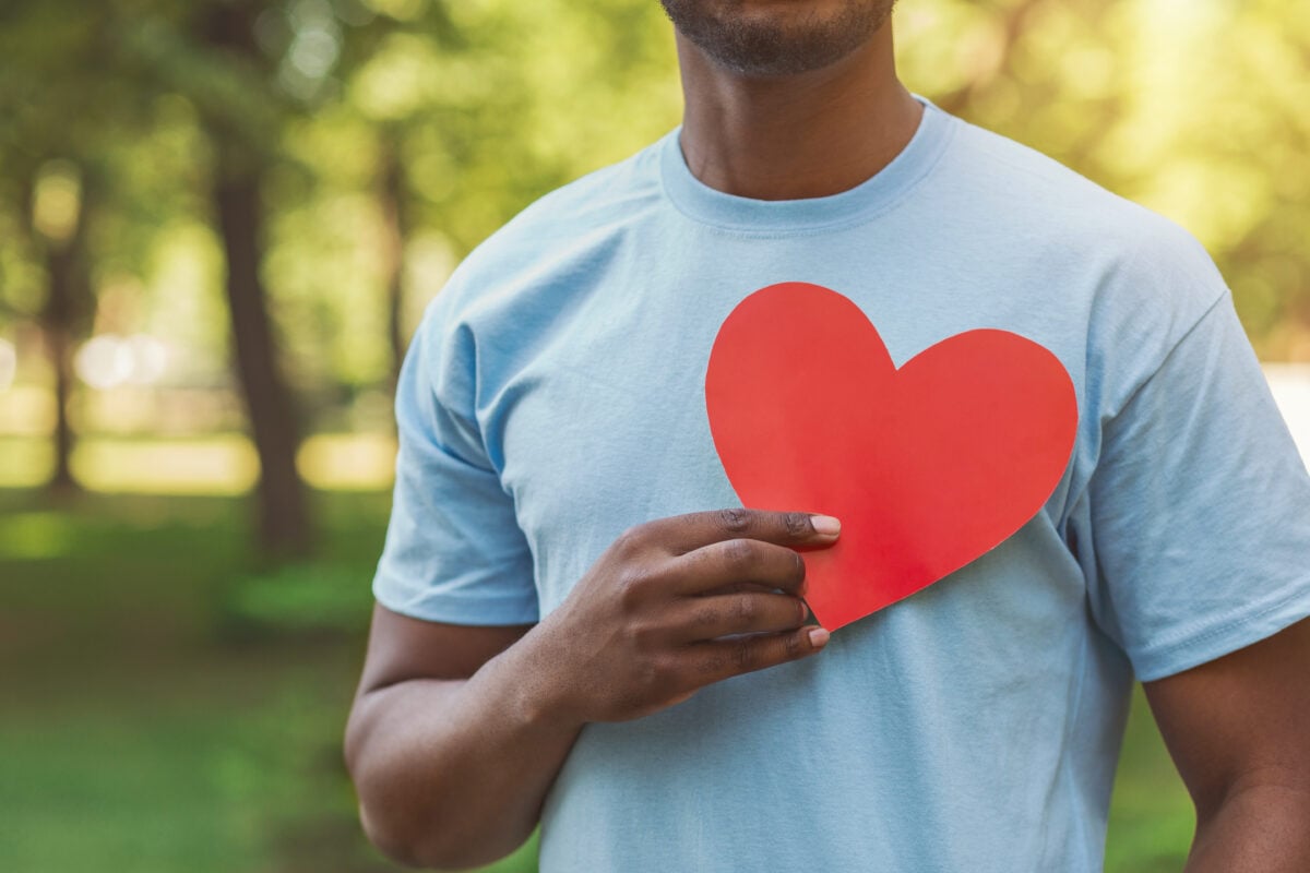 A man holding a paper heart to his chest after a study found swapping dairy for nuts comes with better heart health