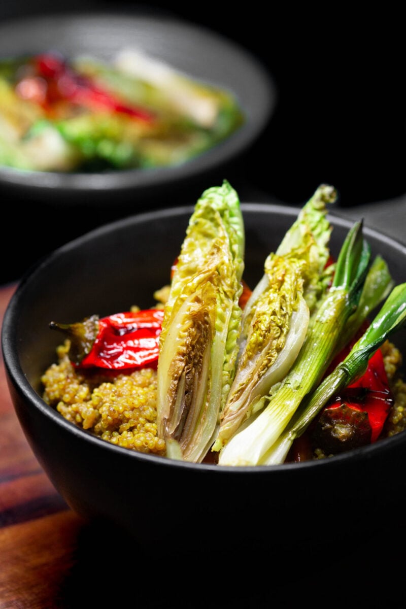 Photo shows a dish of curried quinoa topped with braised greens