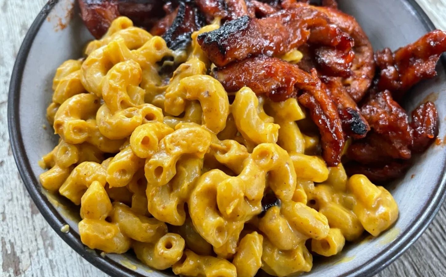 creamy vegan macaroni and plant-based cheese recipe with barbeque soy curls on the side