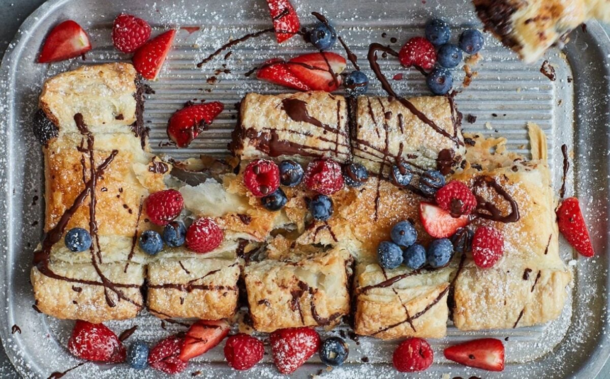 Photo shows a large croissant and chocolate "tearer sharer" made using fresh berries, puff pastry, and chocolate - prepared to a vegan recipe