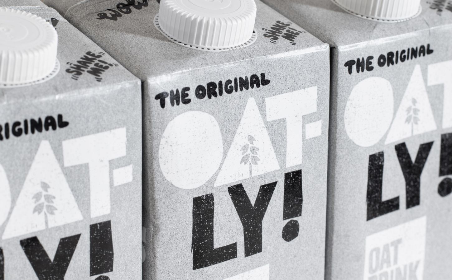 Three cartons of Oatly oat milk. next to each other