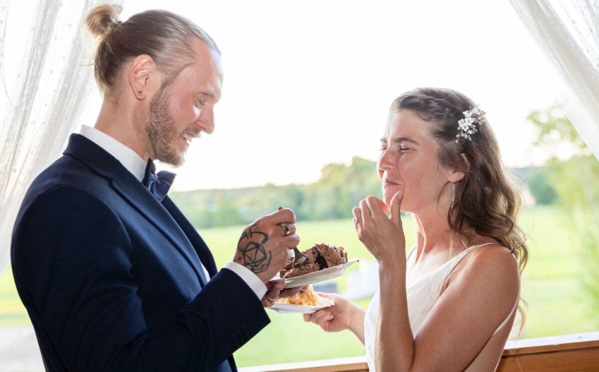Photo shows Andrea and Marcus sharing vegan wedding cake